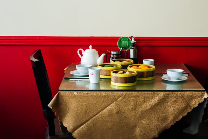 A yum cha brunch featuring a table full of dumplings in bamboo baskets and tea