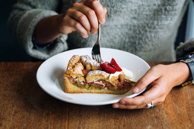 Close up of a piece of rhubarb shortcake being eaten with a fork.