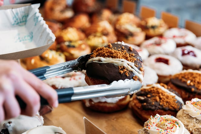 Shop assistant selecting a donut at Belén.