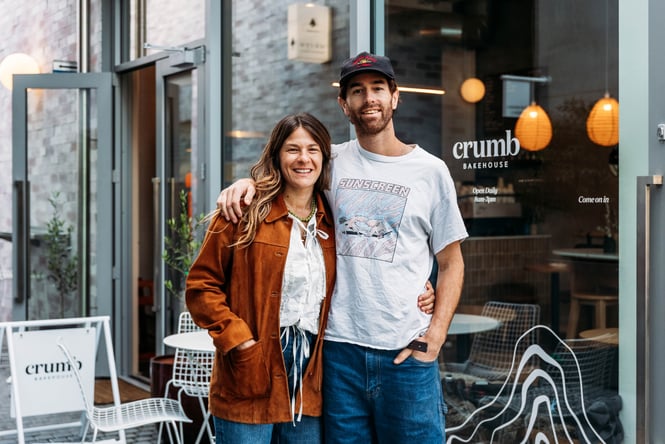 Couple standing outside bakery.