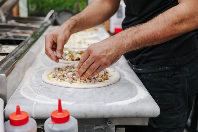 Pizza being made on a table.
