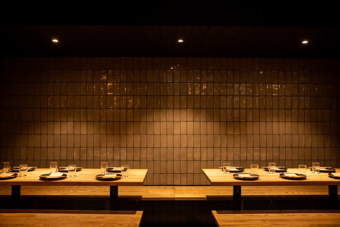 Tables and chairs inside a dimly lit restaurant.