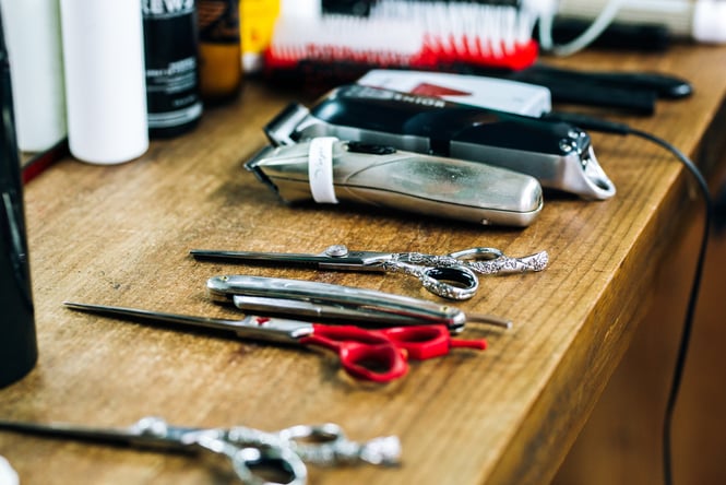 Barber and hairdresser tools on bench at salon