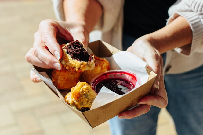 A hand holding deep fried food.