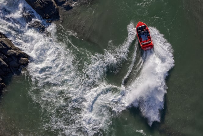 A birdseye view of a jet boat on a river.