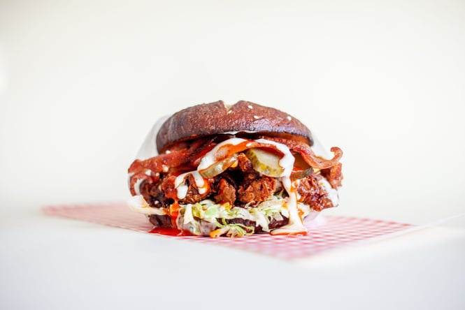 A close up of a delicious looking Parade burger on a white background.
