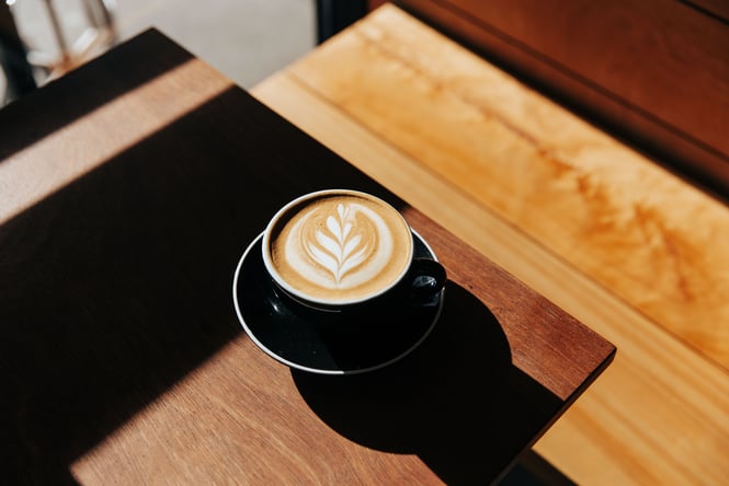A coffee on a table sitting the sunshine.