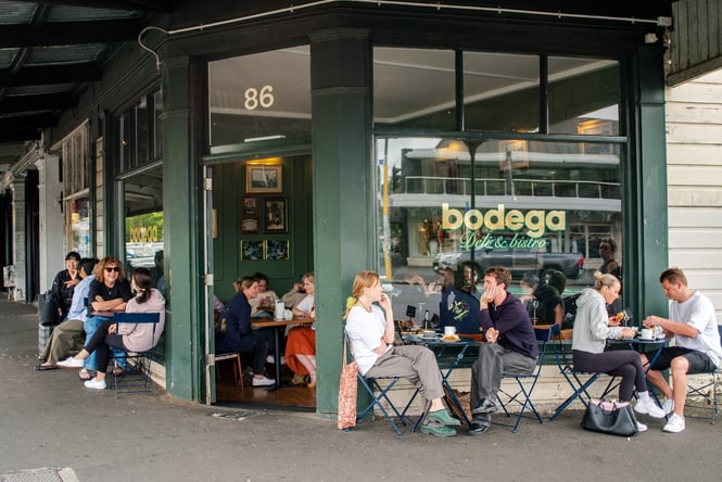 Exterior of Bodega on Ponsonby Road with people sitting on tables outside having lunch