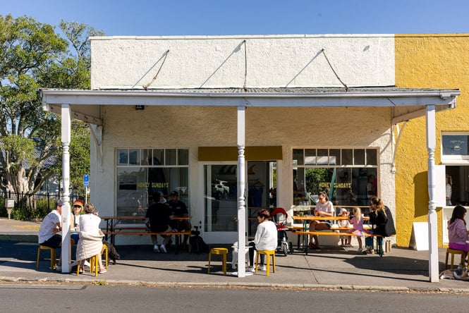Exterior of Honey Sundays cafe in Herne Bay with customers sitting outside in the sun