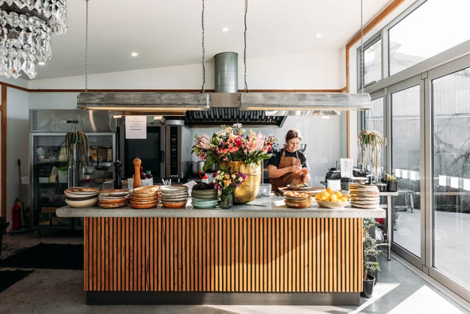 A woman working behind a cafe counter.