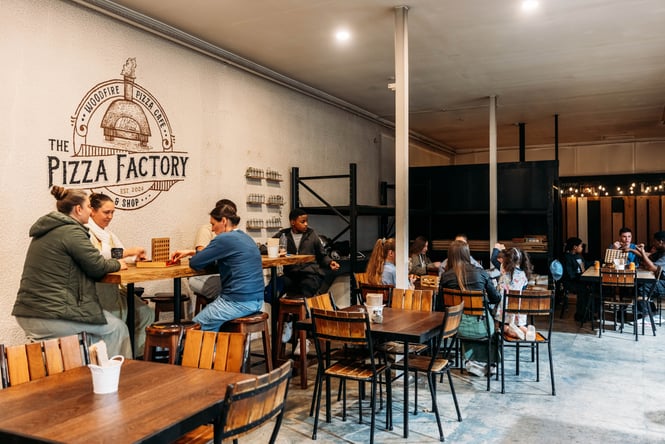Customers sitting at tables and chairs at Cambridge Lane.