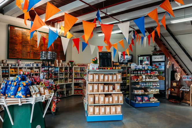 Shelves lined with products on the shop floor and Dutch bunting at De Molen.
