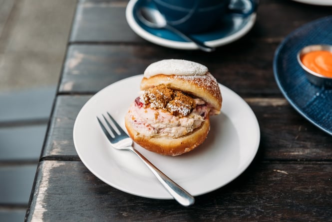 A filled donut on a plate on a table.
