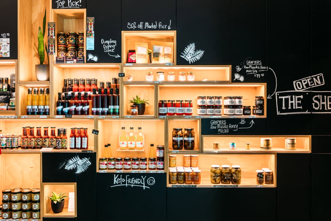 Bottles of sauces on display in wooden boxes.