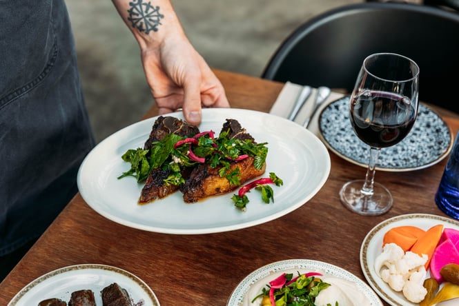 Plate of food being placed on the table at Damascus.