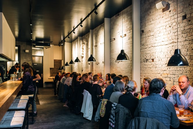 People sitting at a long table at Highwater Eatery.
