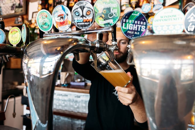 Bartender is pouring a pint of beer at Atlas.