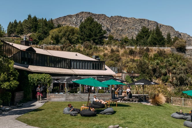 Outdoor tables and umbrellas on the lawn outside Canyon Brewing.