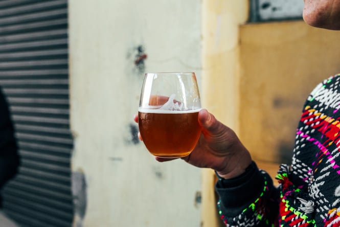Customer holding a glass of beer.