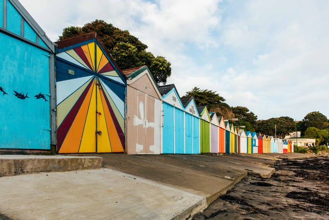 Colorful beach sheds line the shore at Tītahi Bay Beach.