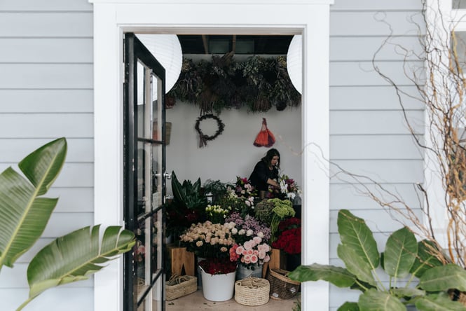 A woman preparing bouquets in a store.