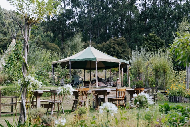 Beautiful garden setting with gazebo and dining chairs at Okuti Garden in Canterbury