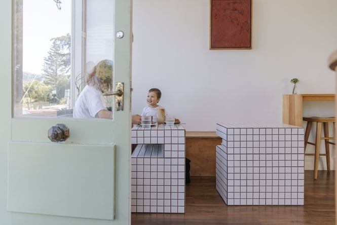 Woman and toddler sitting at white tiled table inside Soulful Coffee Cafe in Diamond Harbour