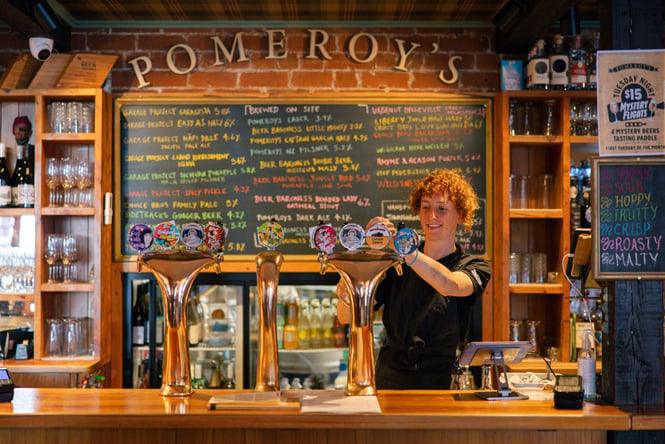 Woman pouring beer from tap at Pomeroy's in Christchurch