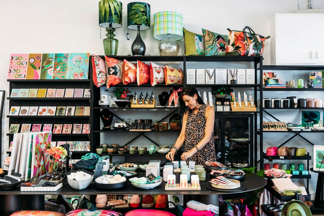 Woman standing at a table looking at products at Eclectic Design House.