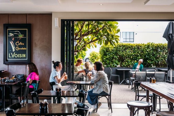 Customers sitting at tables inside and outside at Revive Espresso.
