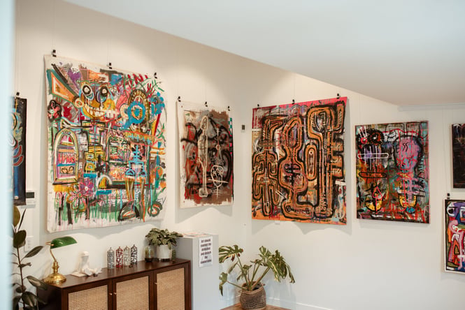 Works of art on a wall inside a gallery.