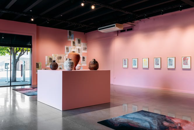 The pink walls of the inside of an art gallery.
