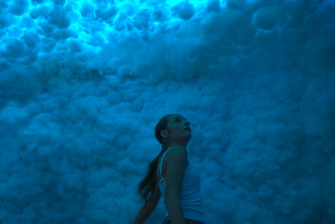 A woman in front of a blue cloud.