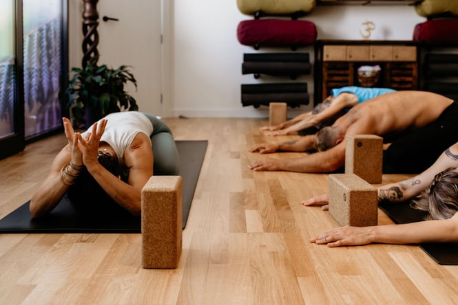 People doing yoga on the ground.