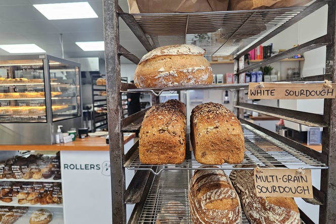 Loaves of bread on racks in a kitchen.