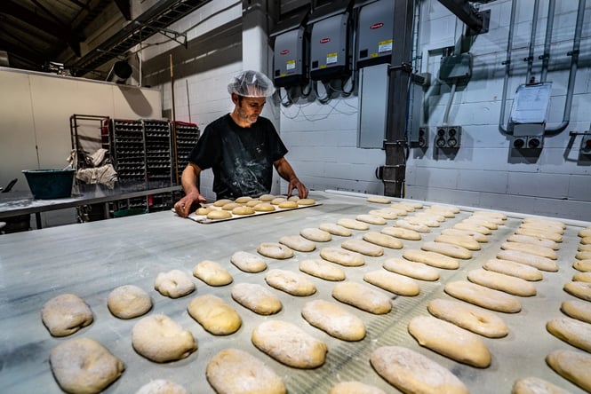 A man baking bread in a dimly lit kitchen.