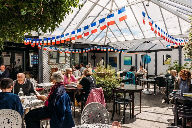 Customers dining outside at Tartines French Cafe.