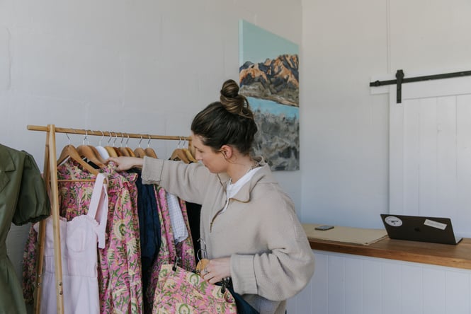 Woman browsing a clothes rack of colourful and floral clothing
