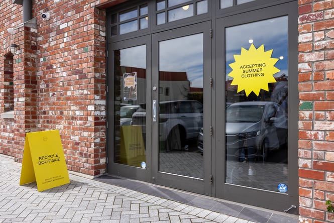 Yellow sign on the footpath by the front entrance to Recycle Boutique.