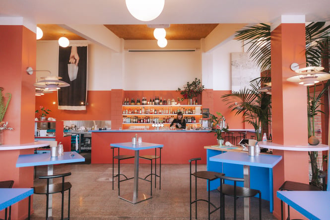 A staff member working behind the bar at the very colourful East Street Hall in Auckland.