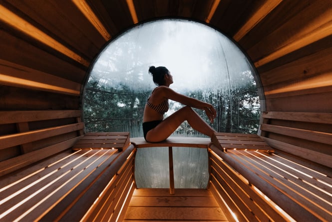 A woman sitting next to a spa pool looking out towards the sky.