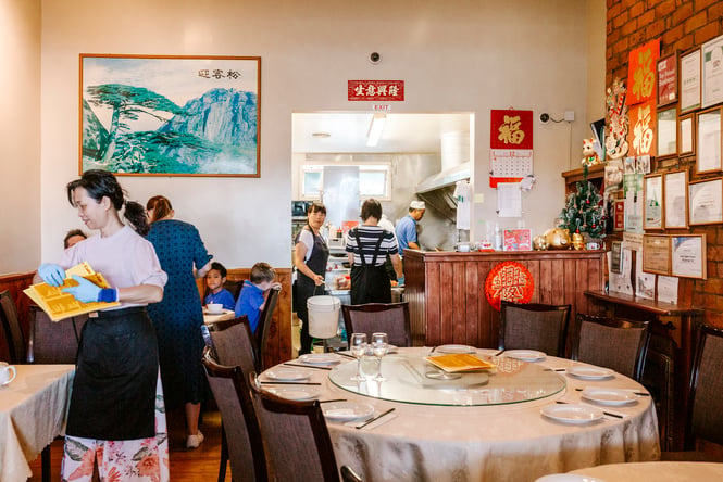Staff chatting with customers in a Chinese restaurant.