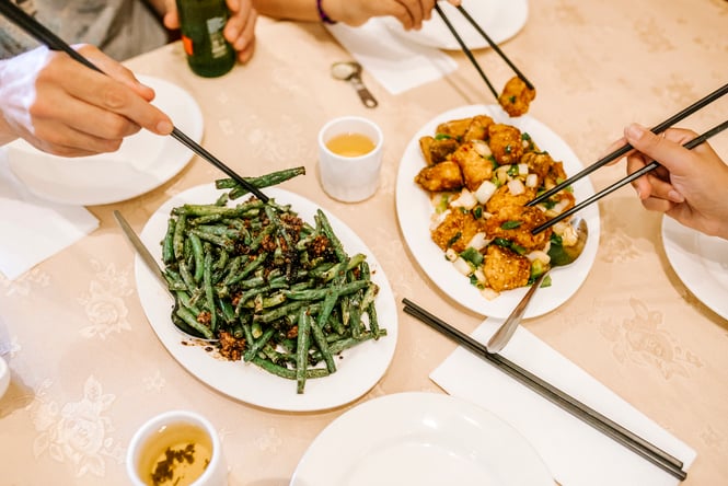 Plates of beans and tofu on a table.