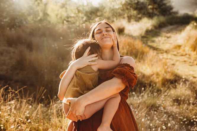 A mother and daughter embracing.