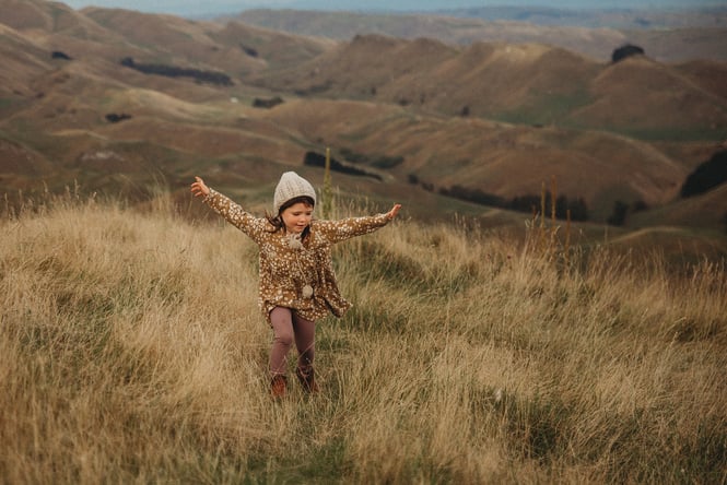 A girl running in grass.