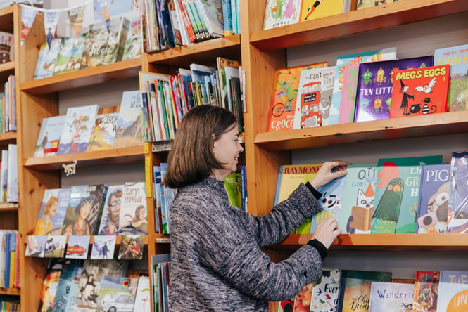 A woman browsing books at Scorpio Books.
