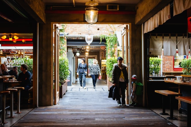 People walking into Ponsonby Central on a sunny day.