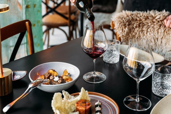 Close up of refined dishes and wine being poured at table at Carrick Winery