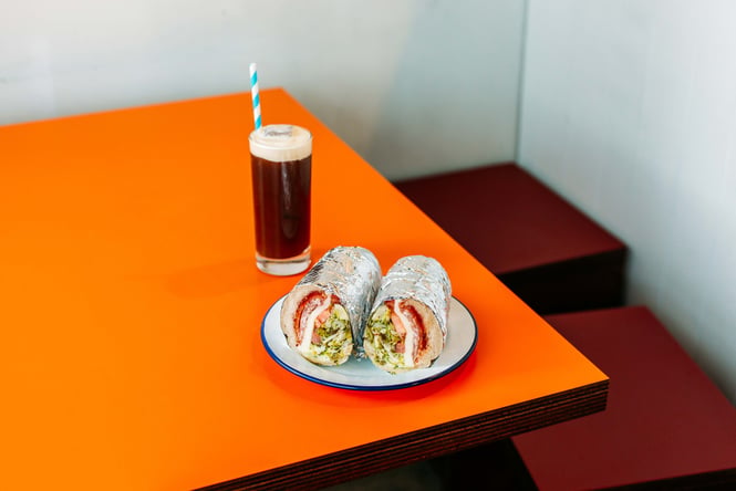 A roll and drink on a table at Romeos.