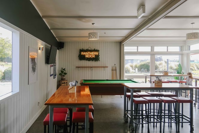 The inside of Panthers Rock bar with tables, chairs and a pool table.